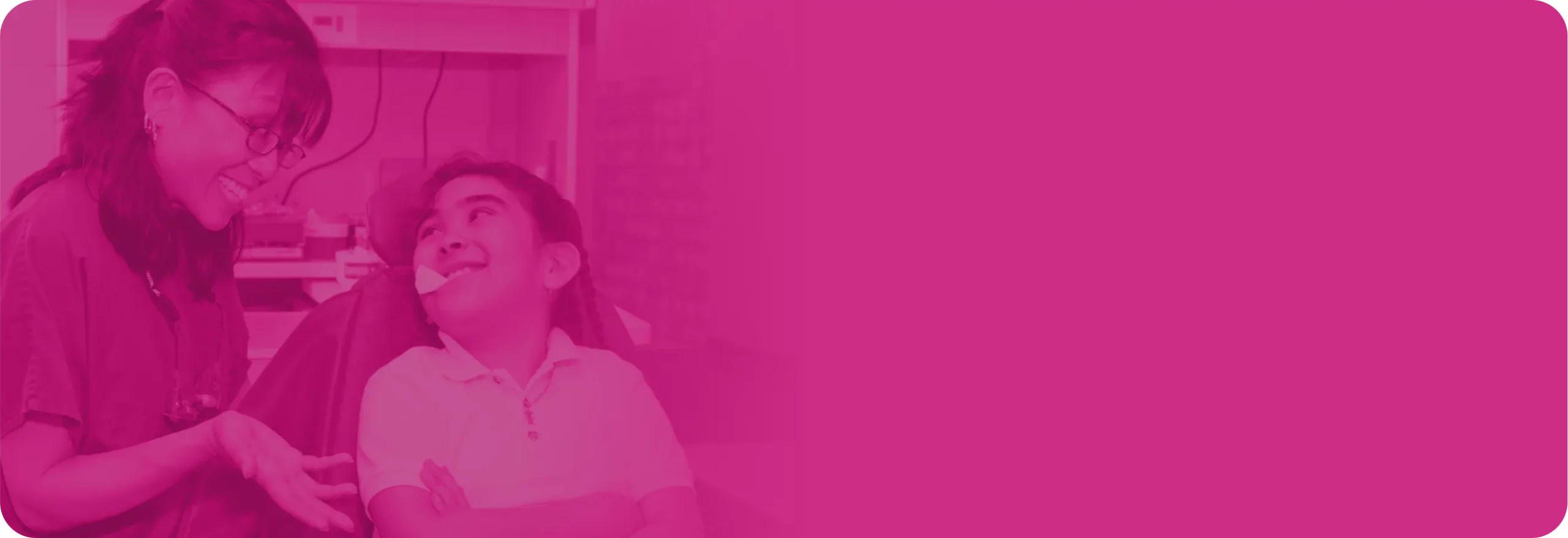 Young child in a dentist chair and a dentist both smiling.