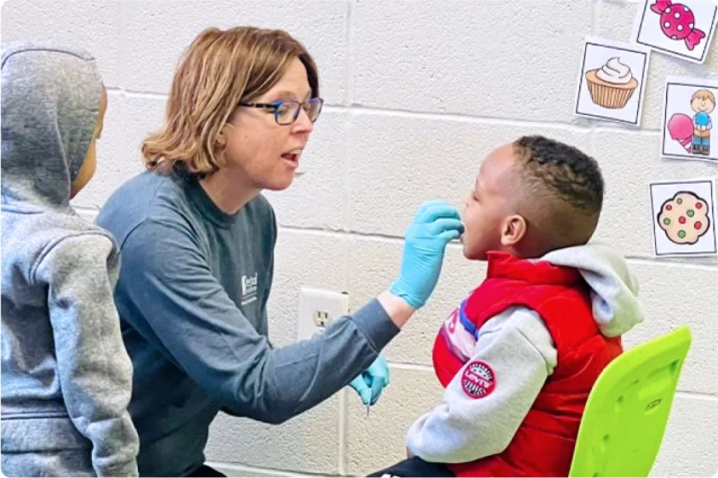 A dentist checking a child's teeth